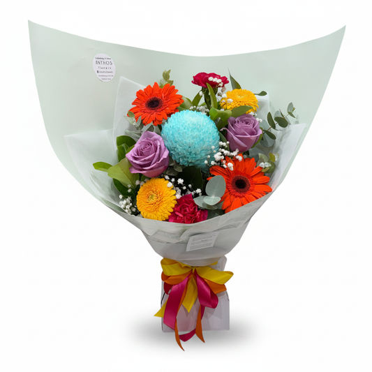 Tutti Frutti bouquet with vibrant seasonal blooms on a clean warm white background